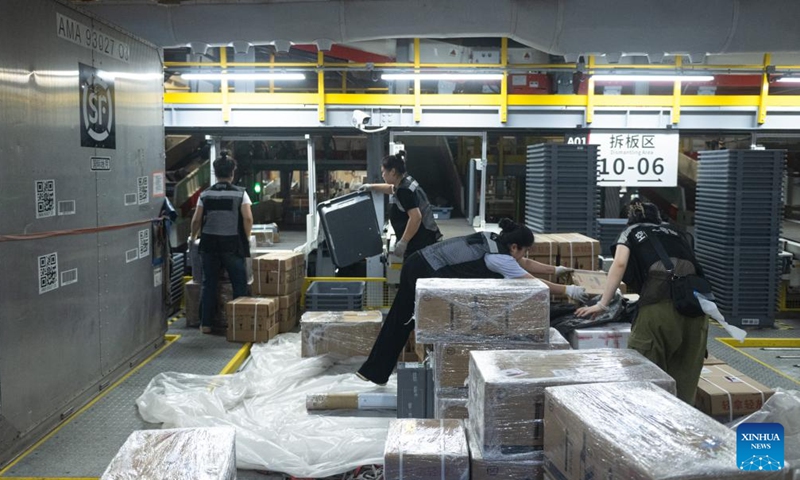 Staff members sort parcels at the transfer center of the Ezhou Huahu Airport in Ezhou, central China's Hubei Province, May 25, 2024. The Ezhou Huahu Airport, an all-cargo hub airport starting operations in July 2022, is now running 48 domestic routes and 17 international routes. The airport owns a 750,000-square meter cargo transfer center with parcel sorting lines adding up to 52 kilometers, and its international throughput has exceeded 80,000 tonnes. (Photo:Xinhua)
