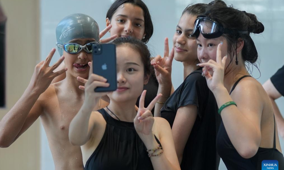 Teenagers from China and France take selfies at a swimming class at ISA Wuhan School in Wuhan, central China's Hubei Province, July 26, 2024. During the 11-day China-France teenagers' summer camp, 20 French teenagers aged 12 to 15 experienced Chinese traditional culture and carried out rich sport activities to enhance cultural exchange and mutual understandings. (Photo: Xinhua)