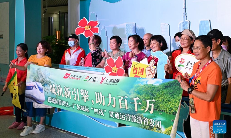 A group of tourists pose for photos at a ceremony marking the connection of four intercity railways linking cities of Zhaoqing, Foshan, Guangzhou, Dongguan and Huizhou at the Panyu Station in Guangzhou, south China's Guangdong Province, May 26, 2024. (Photo: Xinhua)