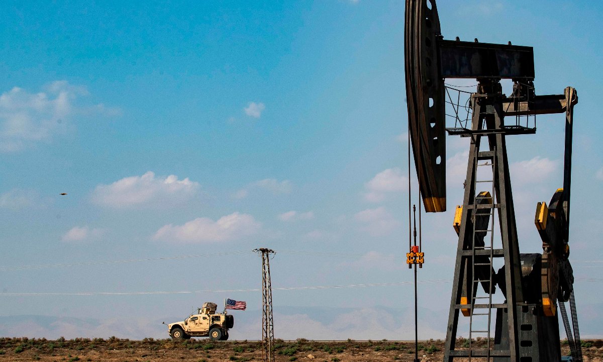 A US military vehicle, part of a convoy arriving from northern Iraq, drives past an oil pump jack in the countryside of Syria’s northeastern city of Qamishli on October 26, 2019. Photo: VCG