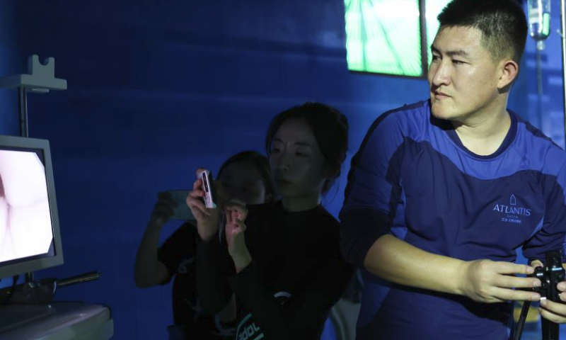 A veterinarian (1st R) perform a gastroscope inspection on a short-finned pilot whale at Sanya Haichang Animal Conservation Center in Sanya, south China's Hainan Province, July 20, 2024. A 3.4-meter long female short-finned pilot whale ran stranded at Haitang Bay of Sanya on July 18. She was rushed to the Sanya Haichang Animal Conservation Center for treatment, where she was found badly dehydrated and unable to feed by herself.

The whale is now under meticulous care by professional breeders and veterinarians. Volunteers at the center also take turns around the clock to keep her from drowning from tilting inside the pool where she is confined for healing. (Xinhua/Zhang Liyun)