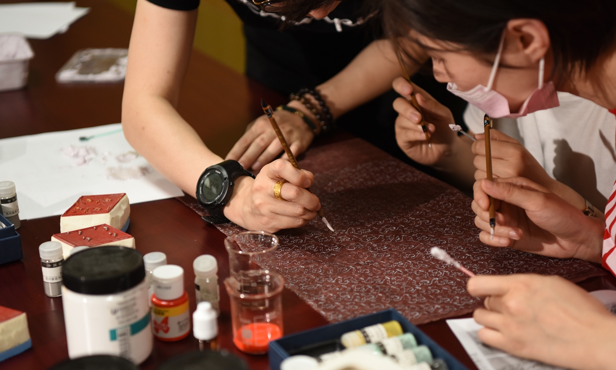 Yang Jiyuan and her apprentices study the details of the drawings on a Western Han Dynasty robe. Photo: Courtesy of Nanjing Yunjin Research Institute