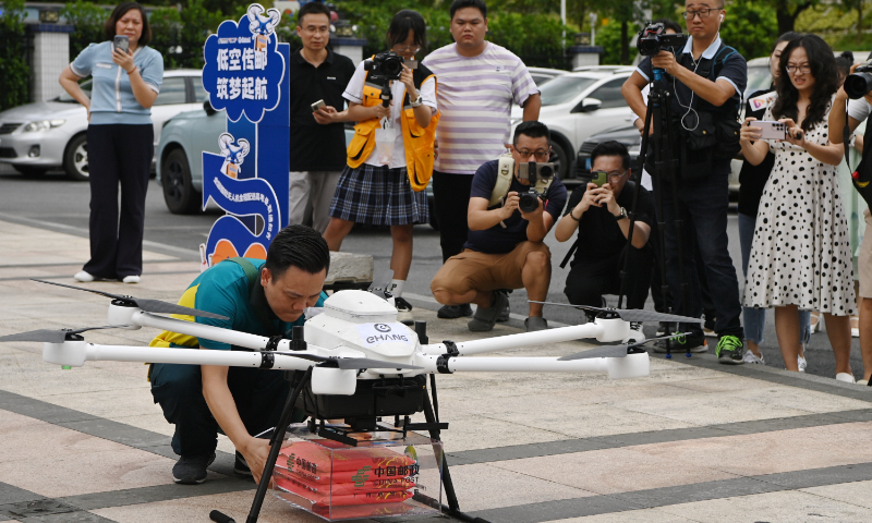 A deliveryman takes college acceptance letters from a drone in Guangzhou, South China's Guangdong Province, on July 15, 2024. Four admission letters were loaded on the drone, which took off from the South China University of Technology and arrived in Huangpu district after a 40-minute journey. It's the first drone delivery of college admission letters in China. Photo: VCG