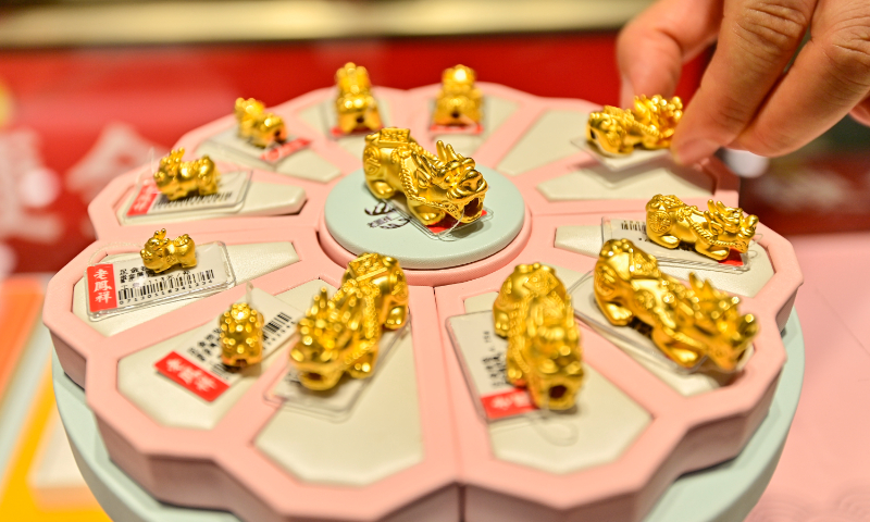 An employee of a gold shop displays gold ornaments in Qingzhou, East China's Shandong Province, on July 29, 2024. The price of gold ornaments stood at 705 yuan ($97.1) per gram on the day. In the first half of the year, affected by a strong rise in gold prices, China's gold consumption totaled 523.753 tons, down 5.61 percent year-on-year, according to statistics from the China Gold Association. Photo: VCG