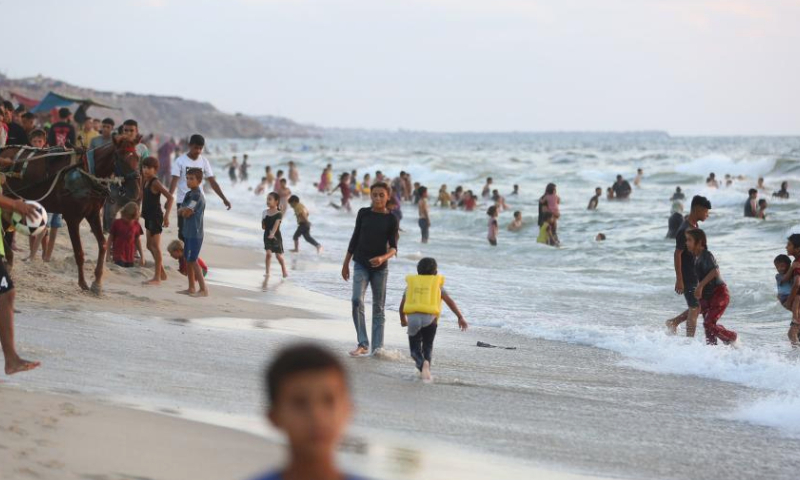 People spend time at seaside during hot weather in the city of Deir al-Balah, central Gaza Strip, on July 19, 2024. (Photo by Marwan Dawood/Xinhua)

