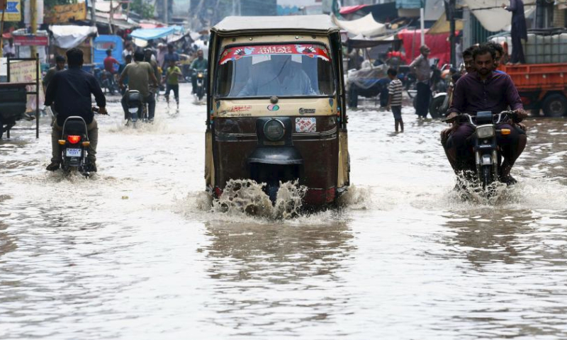 Vehicles wade through a flooded road after heavy rain in southern Pakistani port city of Karachi on July 20, 2024. (Str/Xinhua)