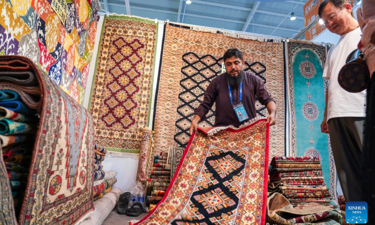 A Pakistani exhibitor (L) introduces carpets to visitors at the South Asia Pavilion during the 8th China-South Asia Expo in Kunming, southwest China's Yunnan Province, July 26, 2024. The 8th China-South Asia Expo runs from July 23 to 28 in Kunming. The expo presents 15 pavilions, including two dedicated to South Asian countries, showcasing a total of approximately 800 booths. (Photo: Xinhua)