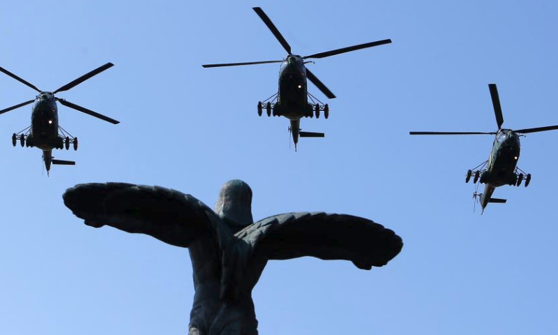 Military helicopters fly over the Statue of Air Heroes during celebrations of the Romanian Aviation and Air Force Day in Bucharest, Romania, July 20, 2024. (Photo by Cristian Cristel/Xinhua)