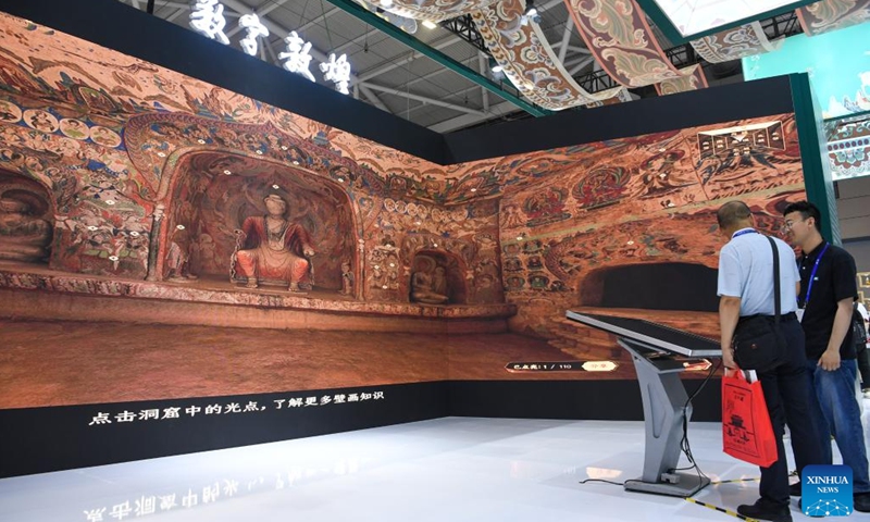 People visit an immersive digitized exhibition of ancient Chinese grottoes during the 20th China (Shenzhen) International Cultural Industries Fair (ICIF) in Shenzhen, south China's Guangdong Province, May 23, 2024. The 20th ICIF opened on Thursday in the southern Chinese metropolis of Shenzhen. The fair will showcase new business forms and new applications through the combination of multimedia such as AI and AR. (Photo: Xinhua)