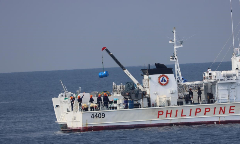  The photo taken on May 14 shows the Philippine Coast Guard's 4409 ship and 9701 ship transferred a blue oil barrel in the waters of China's Xianbin Jiao. Photo: China Coast Guard