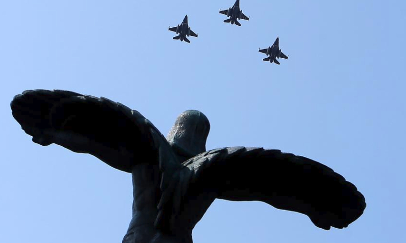 Military airplanes fly over the Statue of Air Heroes during celebrations of the Romanian Aviation and Air Force Day in Bucharest, Romania, July 20, 2024. (Photo by Cristian Cristel/Xinhua)