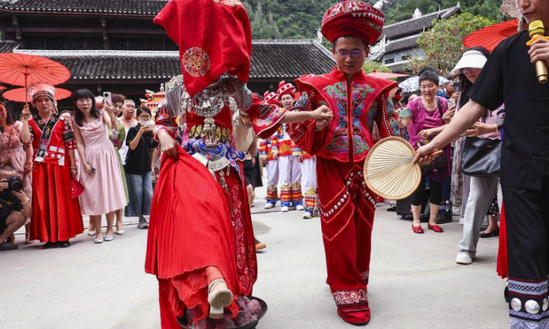 A wedding with Miao ethnic group features is pictured at Chiyou Jiuli Town scenic spot of Pengshui Miao-Tujia Autonomous County, southwest China's Chongqing, July 20, 2024. Local authorities of Pengshui Miao-Tujia Autonomous County has taken advantages of ethnic features to promote its summer tourism. (Photo by Lan Hongguang/Xinhua)