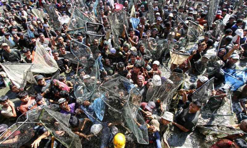 People participate in Festival Memet Ikan, or fish catching festival, at Gemblegan village in Klaten regency, Central Java, Indonesia, July 21, 2024. (Photo by Bram Selo/Xinhua)