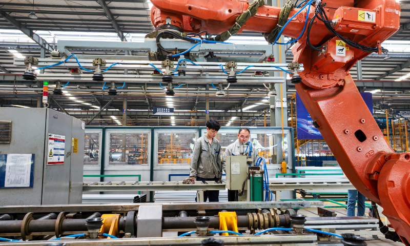 Workers use a smart robotic arm as they race to finish an elevator order that will be shipped overseas, in a factory of YidaExpress Elevator Co in Huzhou, East China’s Zhejiang Province, on May 29, 2024. The elevator company now exports its products to more than 70 countries and regions. Photo: VCG