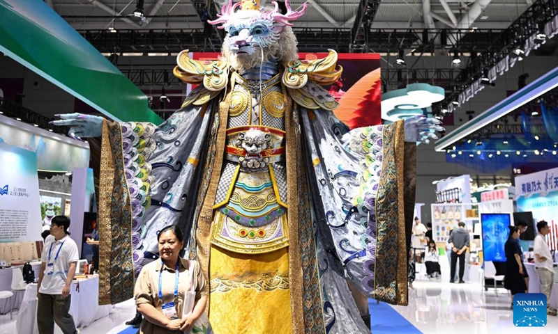 A visitor poses for photos with a mechanical installation mimicking the dragon king, a lord over the sea in Chinese mythology, during the 20th China (Shenzhen) International Cultural Industries Fair (ICIF) in Shenzhen, south China's Guangdong Province, May 23, 2024. The 20th ICIF opened on Thursday in the southern Chinese metropolis of Shenzhen. The fair will showcase new business forms and new applications through the combination of multimedia such as AI and AR. (Photo: Xinhua)