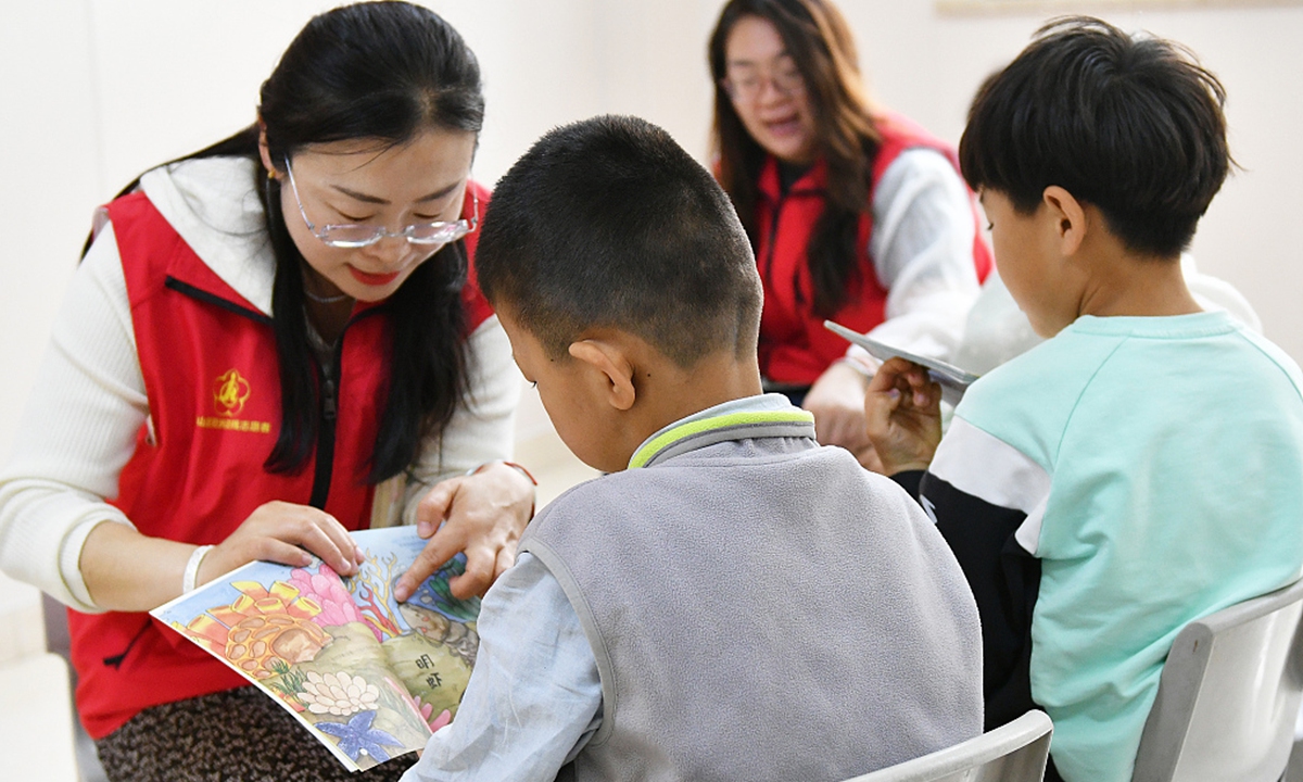 Volunteers help autistic children read picture books at a Children's Rehabilitation Center in Yantai, East China's Shandong Province, on May 17, 2024. Photo: VCG 