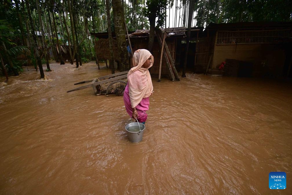 A woman fetches water in a flood-affected area after heavy rains following the landfall of Cyclone Remal in Nagaon district, Assam, northeastern India, on May 29, 2024. Storms and rainfall-induced landslides triggered in the aftermath of Cyclone Remal killed at least 32 people and injured many others across India's West Bengal and four northeastern states, officials said Tuesday.(Photo: Xinhua)