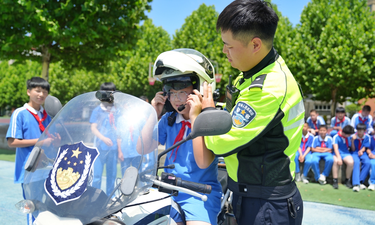 A police officer teach students traffic safety knowledge during a 