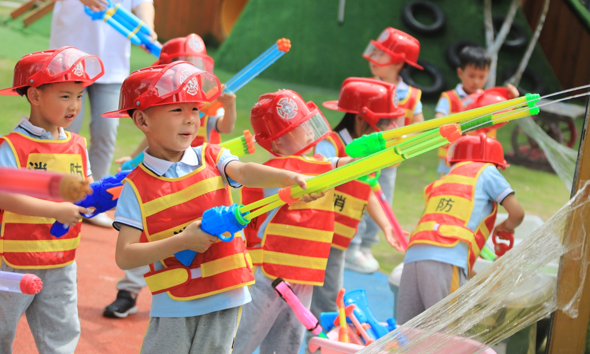 Children experience firefighter training  at Wengpu Kindergarten in Xincheng, Zhoushan, East China's Zhejiang Province, on May 29, 2024.
