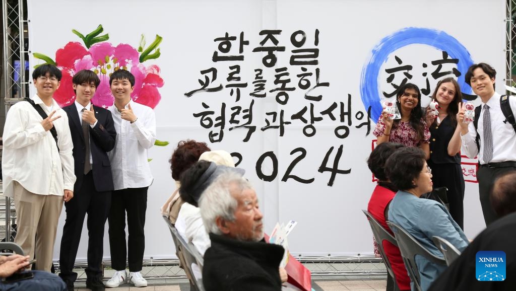 Young people pose for a group photo during the Trilateral Cooperation Secretariat (TCS) Day event in Seoul, South Korea, May 30, 2024. The TCS is a Seoul-based international body for promoting peace and common prosperity among China, Japan and South Korea. Various activities were held on Thursday by the TCS to commemorate the 14th anniversary of the signing of an agreement on its establishment.(Photo: Xinhua)