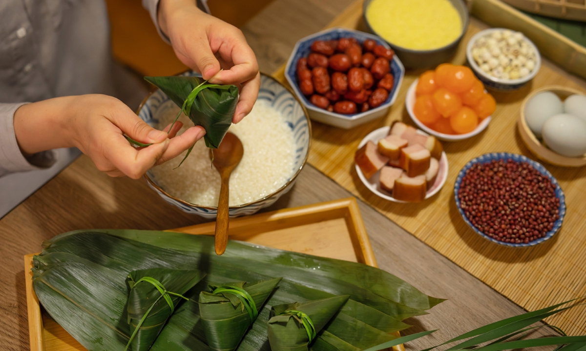 A person makes <em>zongzi</em>, a traditional Chinese food always eaten on the Dragon Boat Festival Photo: VCG