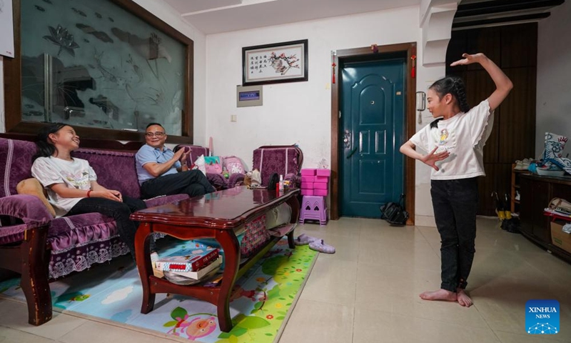 Xie Suqian (R), a pupil of the little Kunqu Opera training class of Shipai Center Primary School, performs Kunqu Opera for her father and sister at home in Kunshan City, east China's Jiangsu Province, May 30, 2024. (Photo: Xinhua)