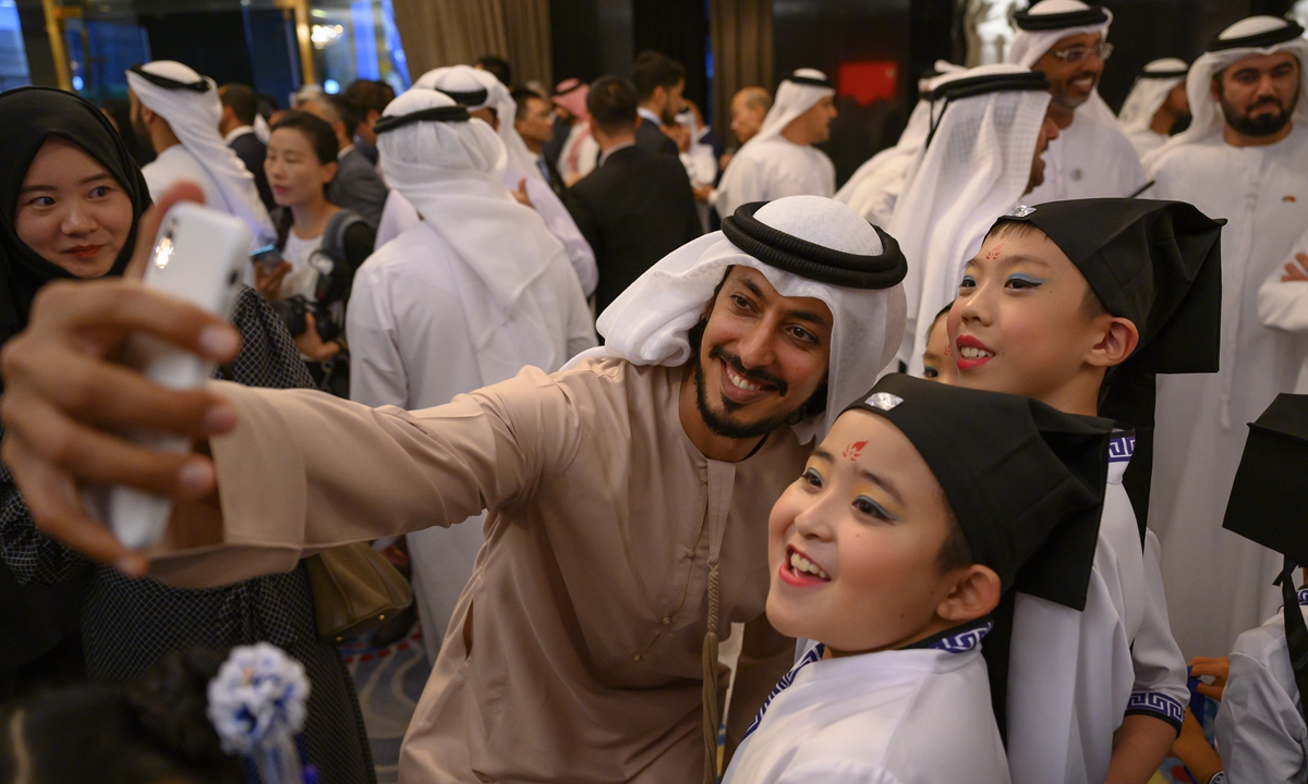 A guest takes a selfie with Chinese children who participated in a cultural performance at the celebration event for the 35th anniversary of the establishment of diplomatic relations between China and the United Arab Emirates held in Beijing on July 23, 2019. Photo: cnsphoto 