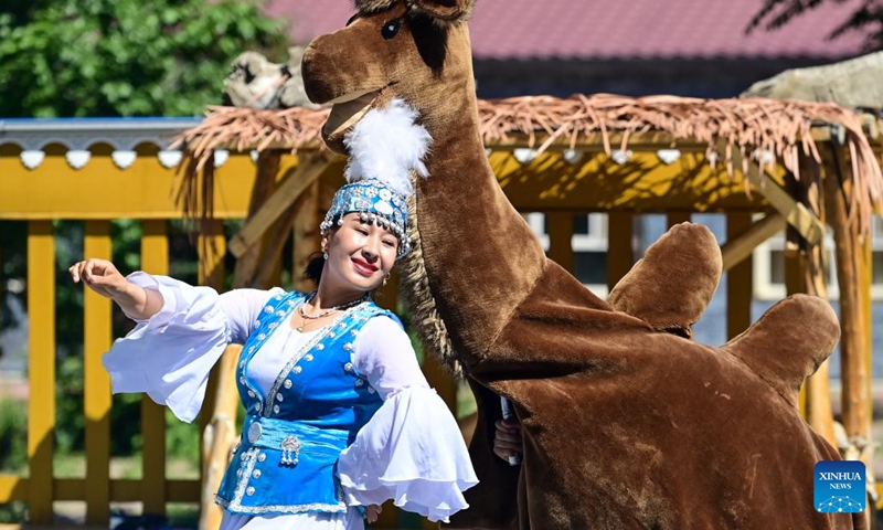 A local dancer greets tourists at Yuliu lane in Emin County, Tacheng Prefecture, northwest China's Xinjiang Uygur Autonomous Region, May 30, 2024. Xinjiang in northwest China has entered its peak tourism season recently. Emin County, located near the China-Kazakhstan border, is a popular tourist destination which provides various rural tour routes and cultural events. (Photo: Xinhua)