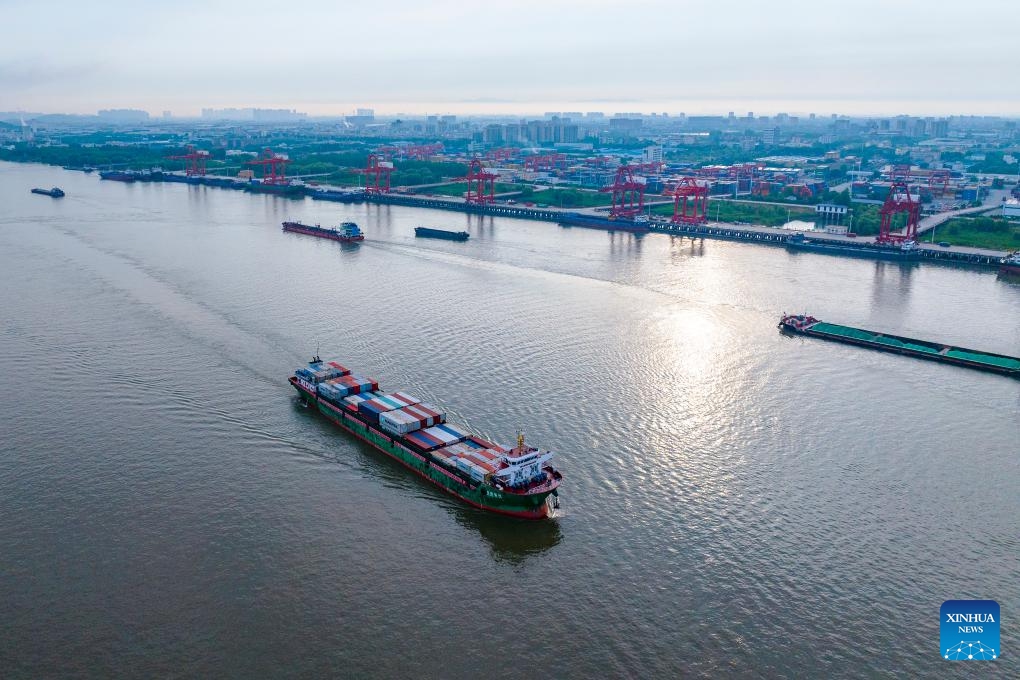 An aerial drone photo taken on May 26, 2024 shows a cargo ship loaded with containers departing from an international container terminal of Zhujiaqiao area at Wuhu Port in Wuhu City, east China's Anhui Province. Wuhu Port in east China's Anhui Province has witnessed rising cargo throughput so far this year, with a large number of containers and vehicles waiting for shipment.(Photo: Xinhua)