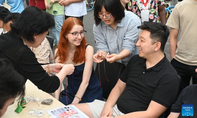 International students learn to weave five-colored bracelets at Tianjin University in north China's Tianjin Municipality, June 6, 2024. (Photo: Xinhua)