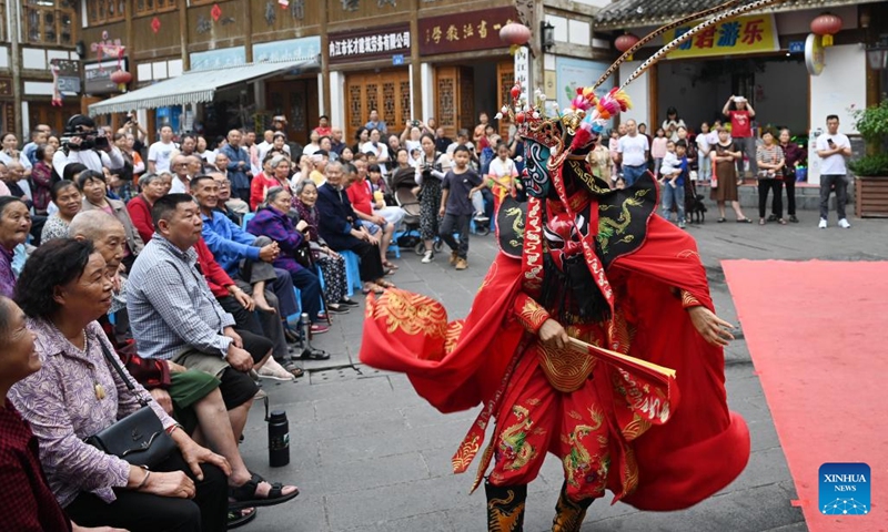 Tourists enjoy the face-changing performance of Sichuan Opera in Neijiang, southwest China's Sichuan Province, June 9, 2024. People enjoy the 3-day holiday of the Dragon Boat Festival, also called Duanwu Festival, which falls on June 10 this year, via various activities across the country. (Photo: Xinhua)