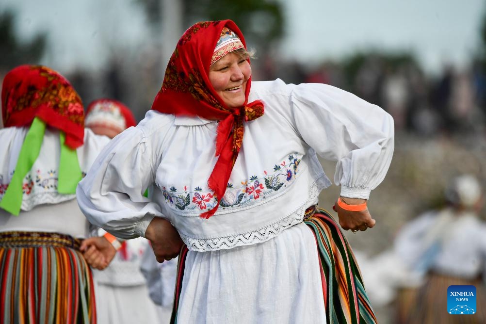 A woman in traditional Estonian folk costume takes part in a dance celebration in Johvi, Estonia on June 8, 2024. More than 1,200 folk dancers from about 100 troops took part in the celebration. (Photo: Xinhua)