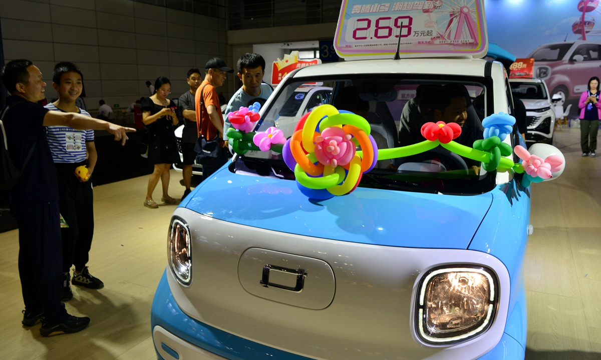 People examine a car with an entry-level price of 26,900 yuan ($3,711) at an auto show in Fuzhou, East China's Fujian Province on June 10, 2024, the last day of the three-day Dragon Boat Festival holidays. The Ministry of Finance has provided 6.44 billion yuan in central subsidy funds for automobile trade-ins in 2024, China Media Group reported. Photo: VCG