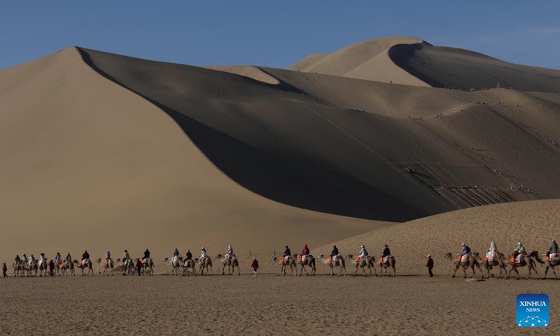 Tourists visit Mingsha Mountain and Crescent Spring scenic spot in Dunhuang, northwest China's Gansu Province, June 9, 2024. People enjoy the 3-day holiday of the Dragon Boat Festival, also called Duanwu Festival, which falls on June 10 this year, via various activities across the country. (Photo: Xinhua)