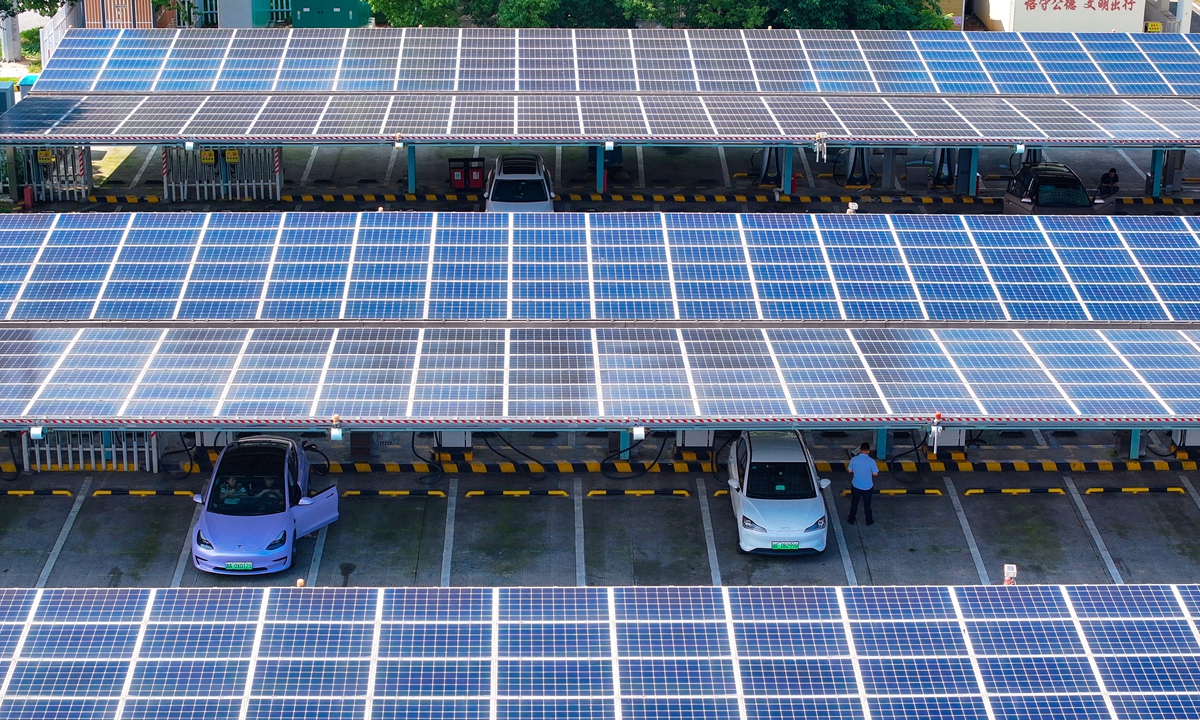 People charge electric vehicles under a roof composed of solar panels at a service station along an expressway in Huzhou, East China's Zhejiang Province on June 11, 2024. The solar roof generates power for the charging poles and facilities inside the service station. The nation's solar power generation capacity stood at about 670 million kilowatts at the end of April, up 52.4 percent year-on-year, data from the National Energy Administration showed. Photo: VCG