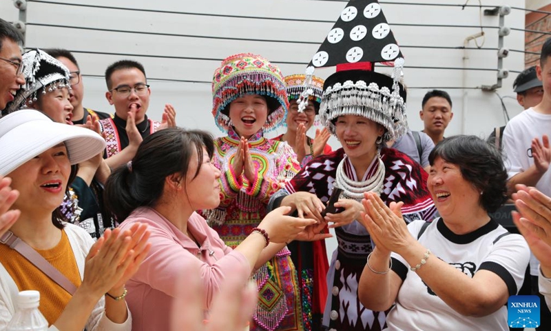 Tourists are greeted by locals wearing traditional costumes in Sanjiao Village, in Shuifu County, southwest China's Yunan Province, June 10, 2024. China saw 110 million domestic tourist trips made during the three-day Dragon Boat Festival holiday, up 6.3 percent from the same period last year, the Ministry of Culture and Tourism said Monday. (Photo: Xinhua)