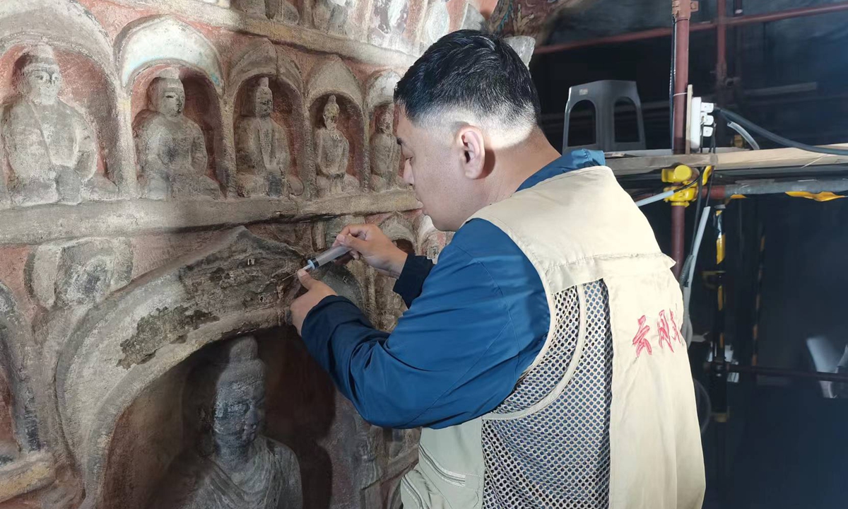 Sun Bo maintains a piece of relics at the Yungang Grottoes. Photo: Courtesy of Sun Bo