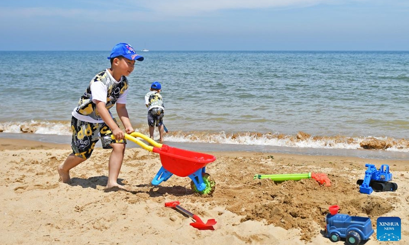 Children have fun at a beach in Yantai, east China's Shandong Province, June 10, 2024. China saw 110 million domestic tourist trips made during the three-day Dragon Boat Festival holiday, up 6.3 percent from the same period last year, the Ministry of Culture and Tourism said Monday. (Photo: Xinhua)