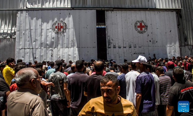 Palestinians gather to receive food aid in the Sheikh Radwan area in northern Gaza City, on June 11, 2024. (Photo: Xinhua)