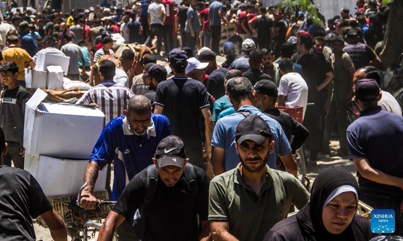 Palestinians gather to receive food aid in the Sheikh Radwan area in northern Gaza City, on June 11, 2024. (Photo: Xinhua)