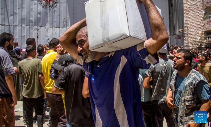 Palestinians gather to receive food aid in the Sheikh Radwan area in northern Gaza City, on June 11, 2024. (Photo: Xinhua)