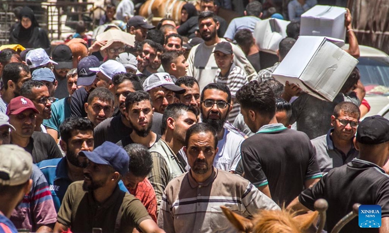 Palestinians gather to receive food aid in the Sheikh Radwan area in northern Gaza City, on June 11, 2024. (Photo: Xinhua)