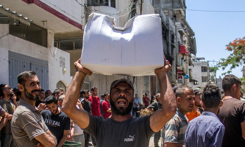 Palestinians gather to receive food aid in the Sheikh Radwan area in northern Gaza City, on June 11, 2024. (Photo: Xinhua)