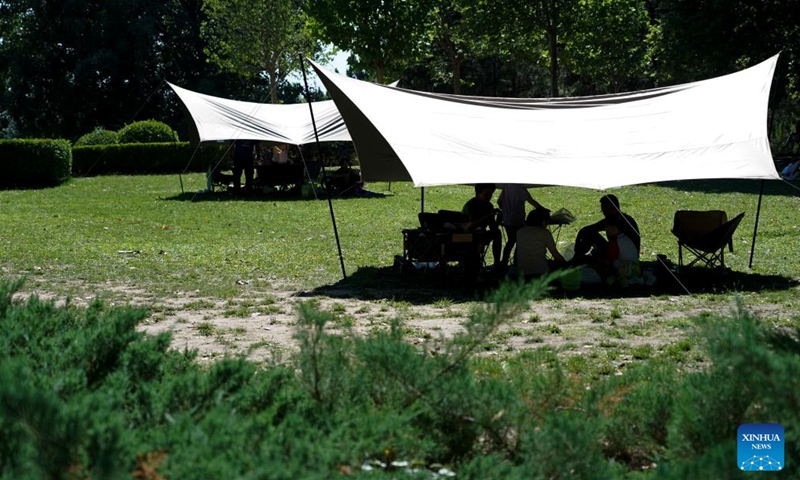 People stay under a canopy to shield themselves from the sun at Chaoyang Park in Beijing, capital of China, June 9, 2024. (Photo: Xinhua)