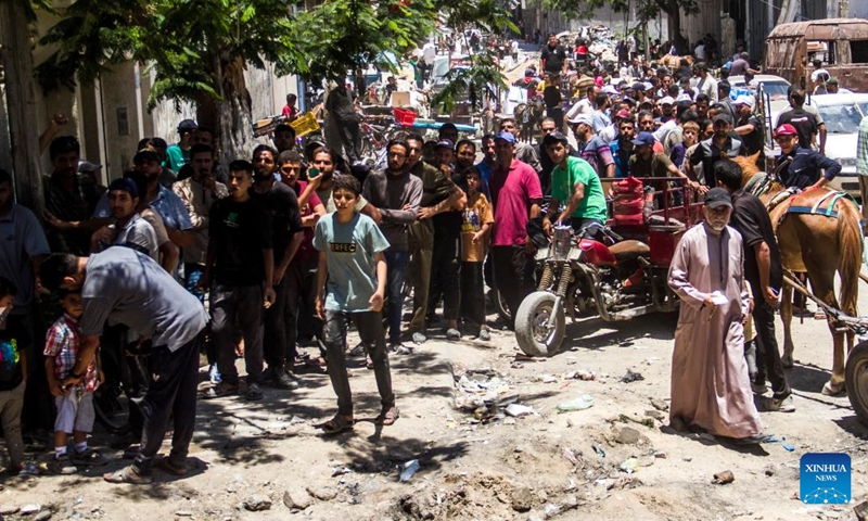 Palestinians gather to receive food aid in the Sheikh Radwan area in northern Gaza City, on June 11, 2024. (Photo: Xinhua)