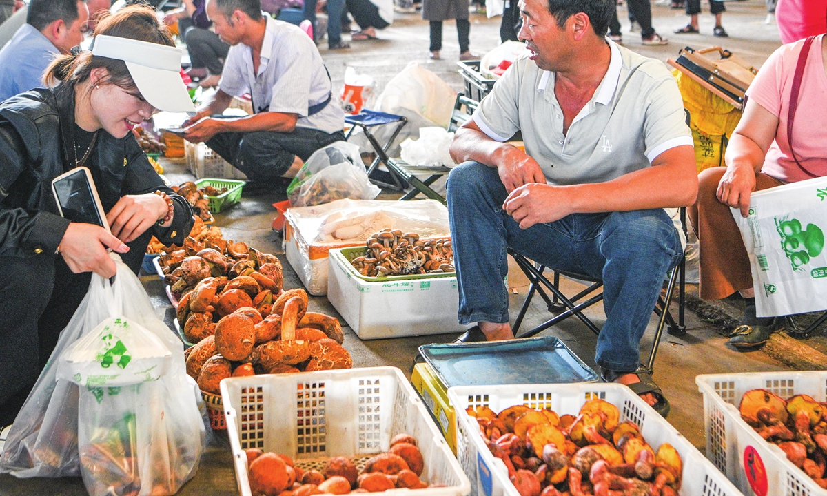 Vendors sell edible wild mushrooms at a vegetable market in Kunming, Southwest China's Yunnan Province on June 13, 2024. The peak season for trading wild edible mushrooms, a beloved seasonal delicacy in Yunnan, has arrived, enticing countless foodies who covet the enchanting aura. Photo: cnsphoto