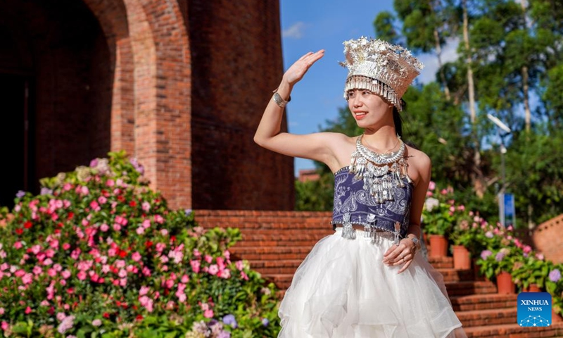 A tourist poses for photos at Dongfengyun town in Mile, southwest China's Yunnan Province, on June 13, 2024.