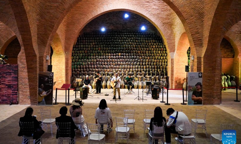 Visitors watch a performance in a museum of Dongfengyun town in Mile, southwest China's Yunnan Province, on June 13, 2024. 