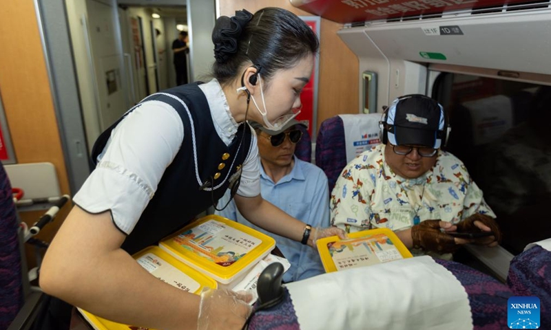 A stewardess serves meal for passengers on the train G8388, June 15, 2024.