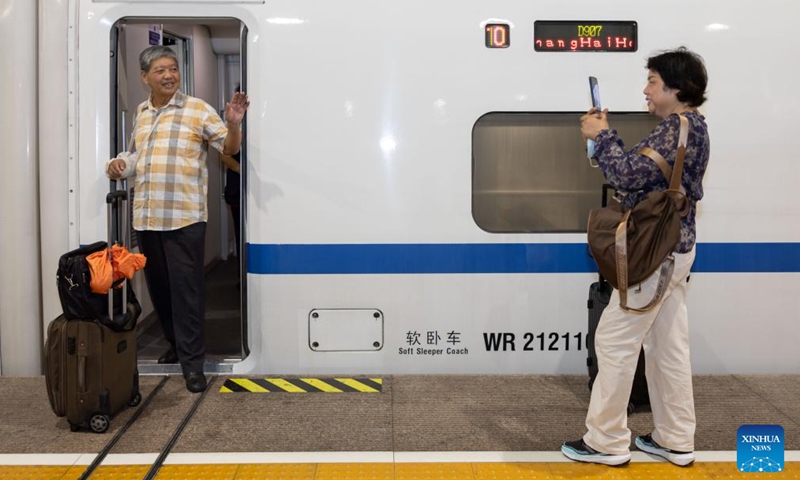 A passenger poses for photos when boarding the high-speed sleeper train D907 bound for Hong Kong's West Kowloon Station at Shanghai Hongqiao Railway Station in east China's Shanghai, June 15, 2024. (Photo: Xinhua)